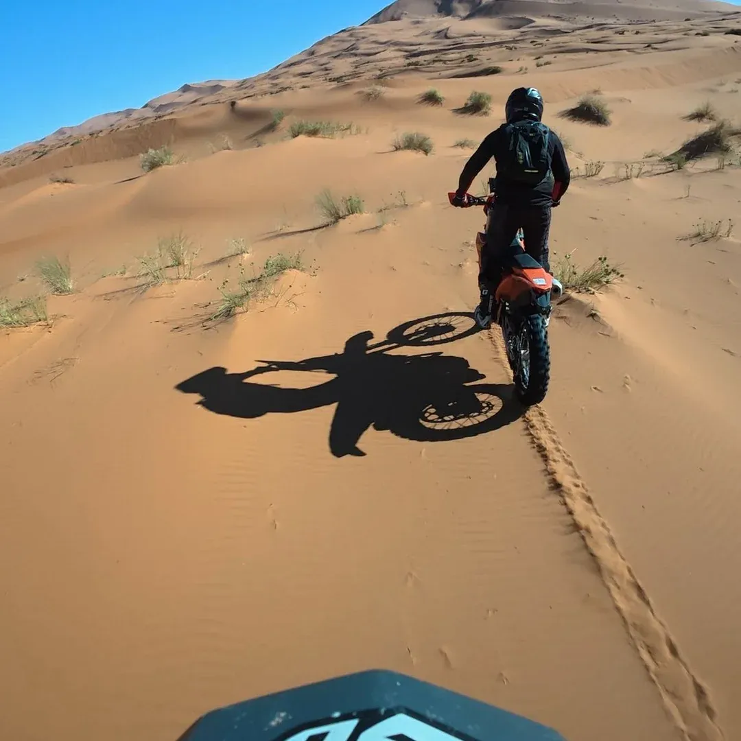 Une moto dans les dunes, vue depuis le guidon